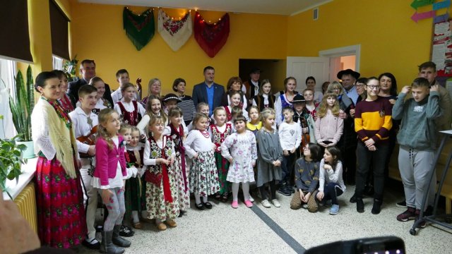 A kép a lengyel testvérvárosban készült. A képen néhány füzesgyarmati látogató, valamint a vendéglátók, és a műsort adó gyerekek csoportja látható.