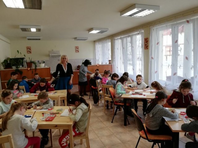 Víz világnapja rajzverseny A képen egy teremben az asztaloknál ülő és rajzoló gyerekek, valamint a tanáraik láthatóak.